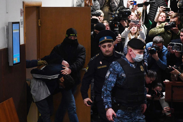 At least 137 people, including three children, were killed when camouflaged gunmen stormed the Crocus City Hall, in Moscow's northern suburb of Krasnogorsk, and then set fire to the building on March 22 evening. (Olga Maltseva / AFP - Getty Images)