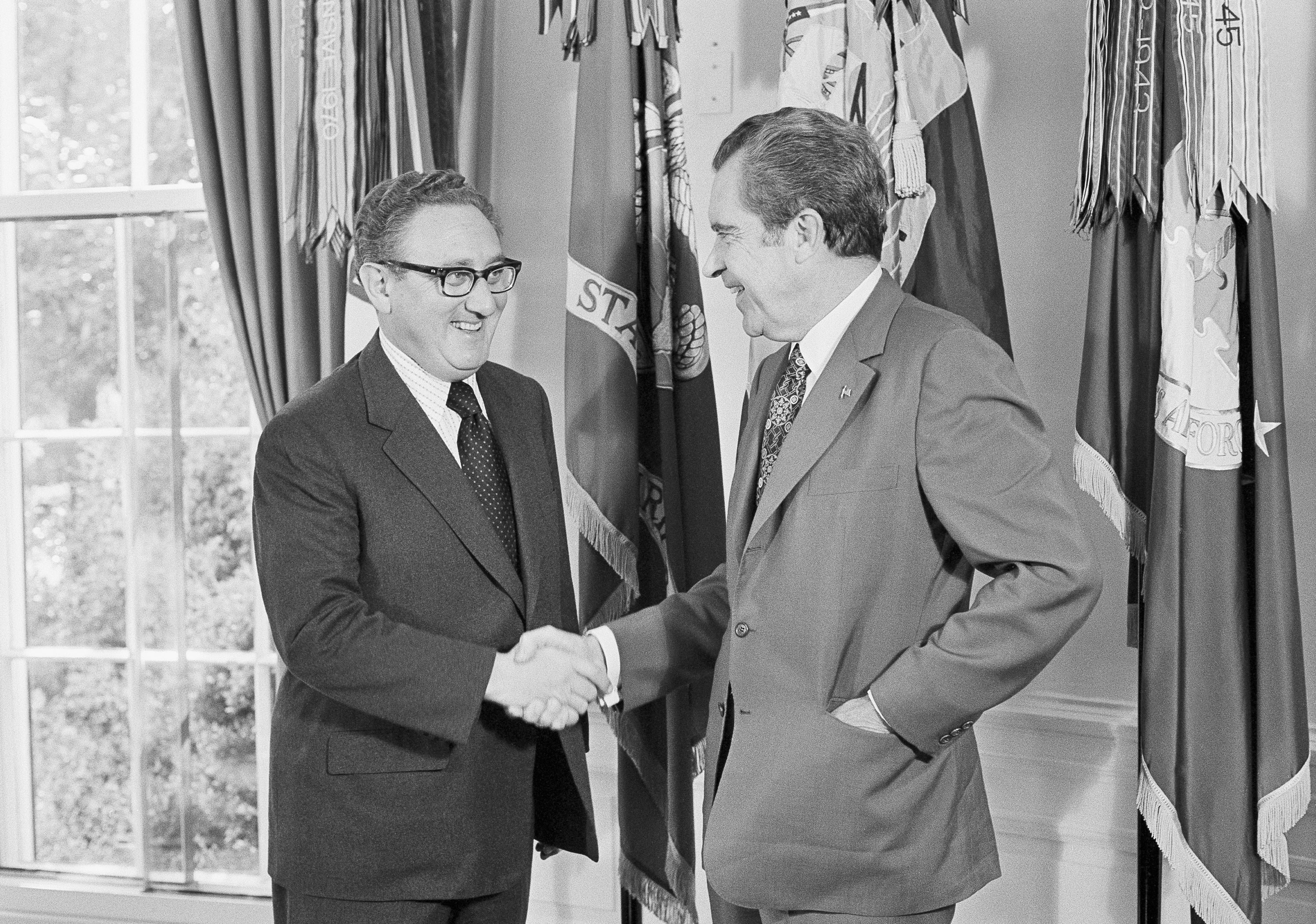 <p>President Richard Nixon, right, offers his congratulations to his Secretary of State Henry Kissinger, after he was awarded the Nobel Peace Prize in 1973</p>