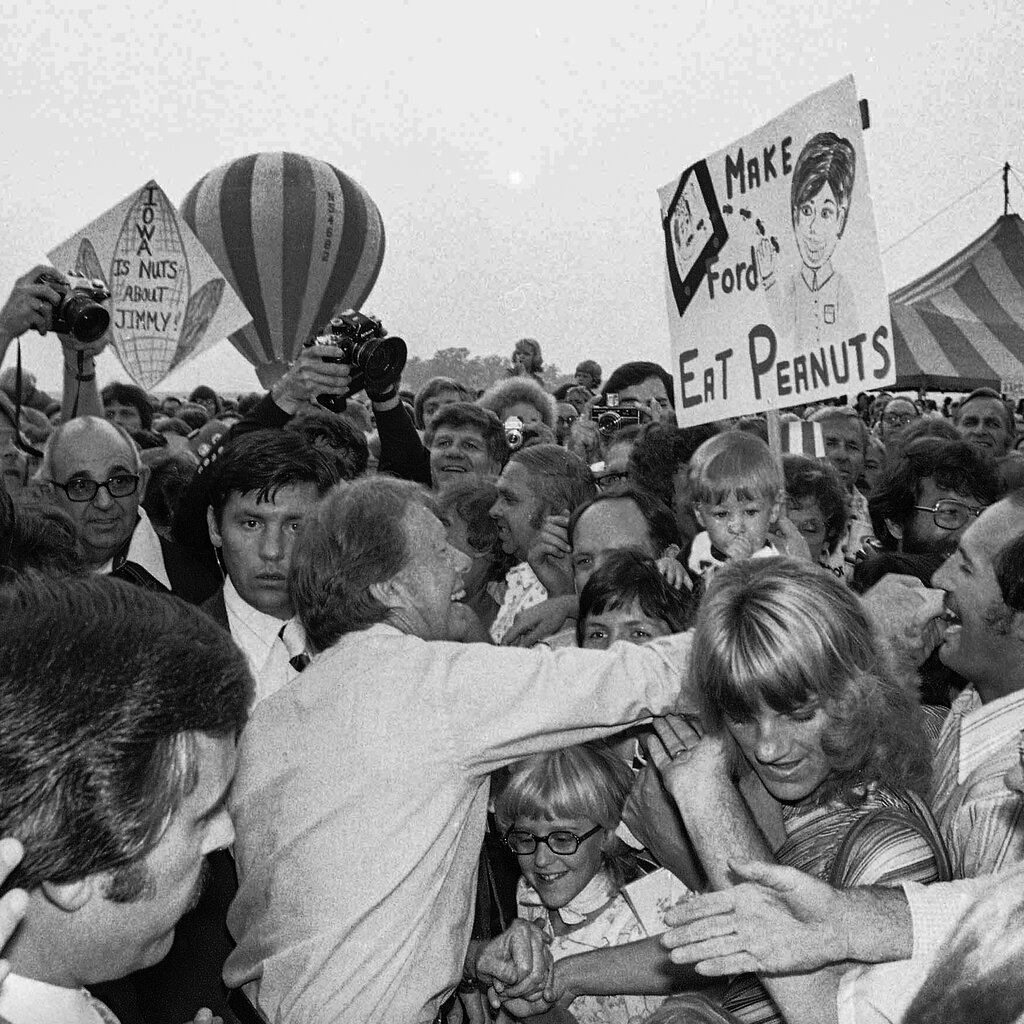 Jimmy Carter shaking hands in a crowd in Iowa.