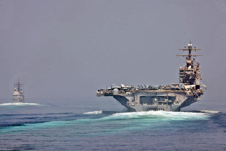 The aircraft carrier USS Abraham Lincoln follows the guided-missile cruiser USS Cape St. George in the Strait of Hormuz in May 2012. US Navy photo by Mass Communication Specialist 3rd Class Alex R. Forst